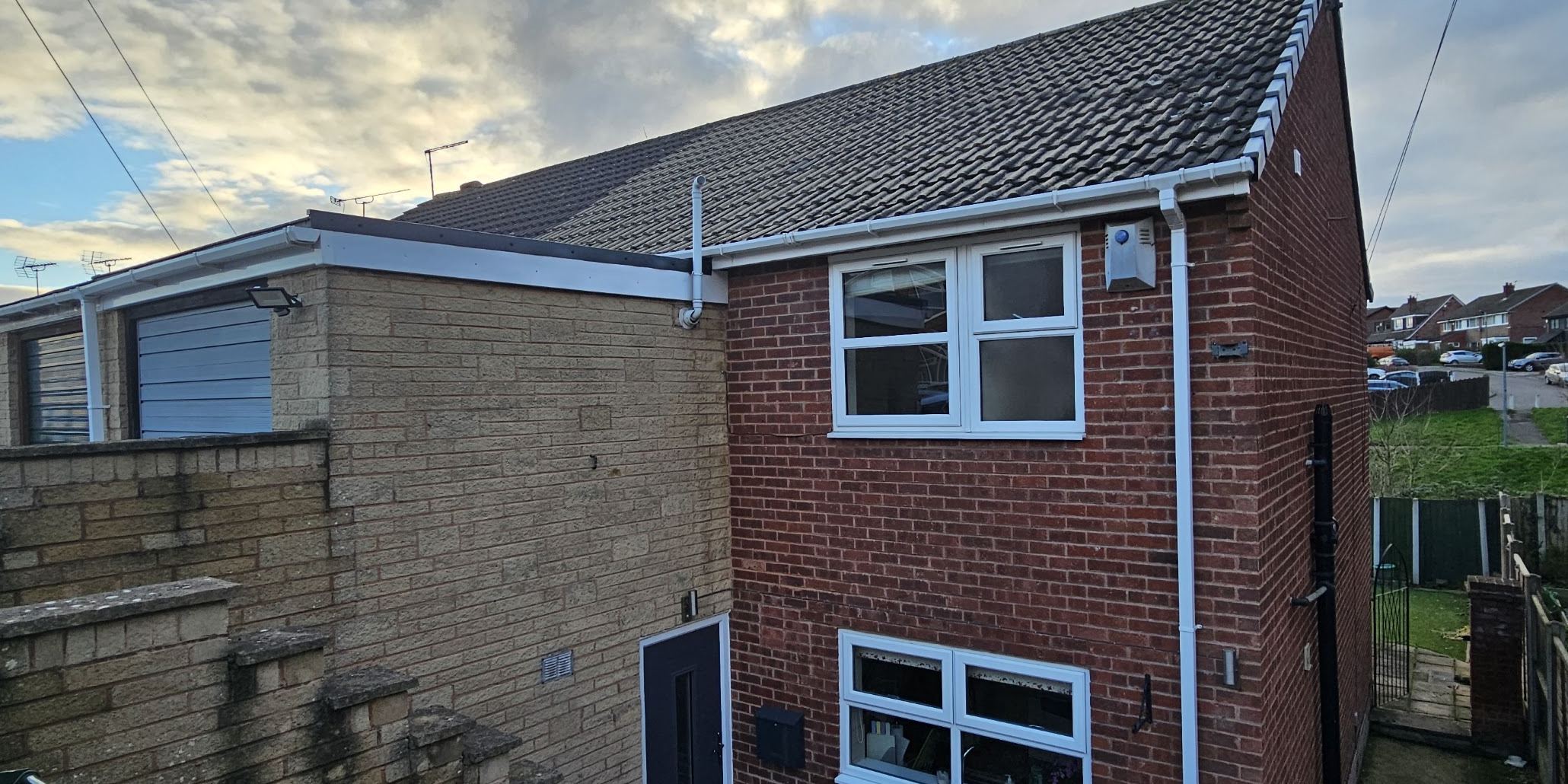 A cleaned roofline with clear guttering and bright white fascias and soffits