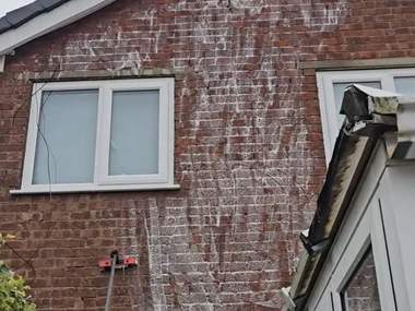 Soft wash treatment running down a brick gable